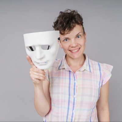 A woman smiling because she is learning to drop the mask of main character syndrome.