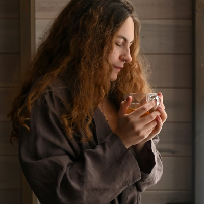 Woman experiencing the apathy paradox with a cup of tea by a window