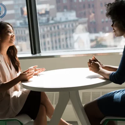 two women talking at a table