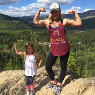 woman and child flexing muscles in the mountains