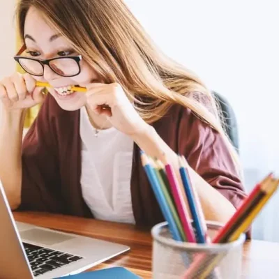 girl biting her pencil in half out of frustration with school