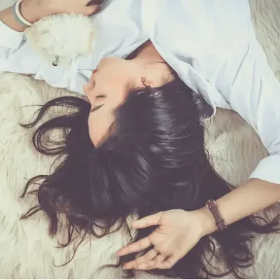 woman laying on furry blanket with puppy