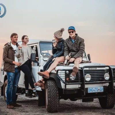 group of friends sitting on a jeep